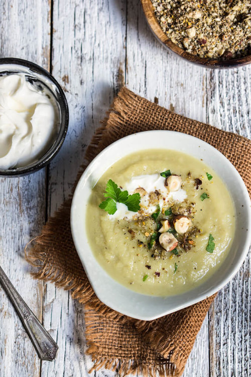 Celery root and leeks soup - creamy and aromatic, served with garlic crème fraiche, toasted spices, hazelnuts, and lots of fresh parsley, this soup is a winter favorite. | www.viktoriastable.com