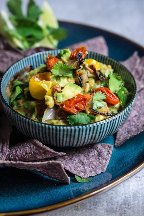 Roasted vegetable guacamole - this slight twist on the beloved avocado dip is bursting with lovely charred flavors of sweet caramelized onions, tomatoes and jalapeños, smoky cumin, and bright citrus and floral notes from the lime and cilantro. | www.viktoriastable.com