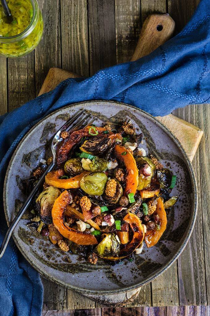Roasted brussels sprouts and squash salad with horseradish dressing - this warm salad combines all the favorite flavors of fall - the sweetness of roasted veggies and dry fruit, with crunchy nuts, and a pungent horseradish dressing that ties them all in. | www.viktoriastable.com