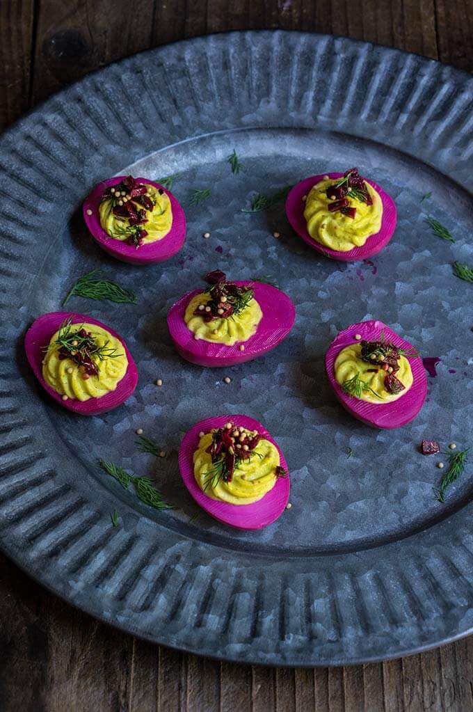Beet-pickled curry deviled eggs - pickled in beet marinade for a gorgeous magenta color, then stuffed with a delicious curry filling, they make a spectacular appetizer, and a great way to utilize those leftover Easter eggs. | www.viktoriastable.com