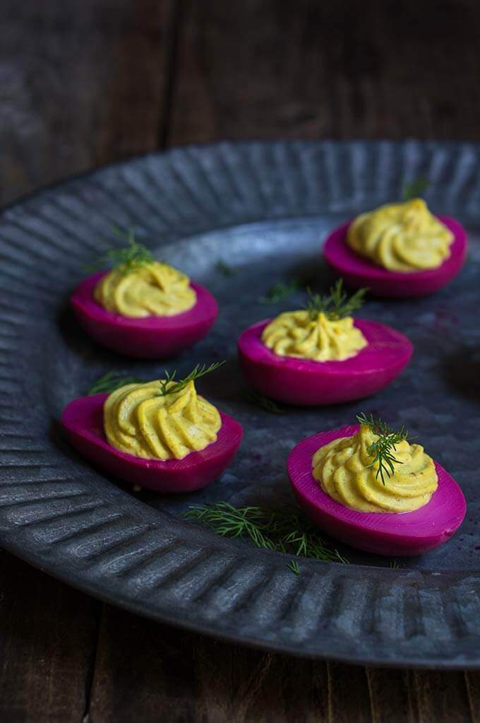 Beet-pickled curry deviled eggs - pickled in beet marinade for a gorgeous magenta color, then stuffed with a delicious curry filling, they make a spectacular appetizer, and a great way to utilize those leftover Easter eggs. | www.viktoriastable.com