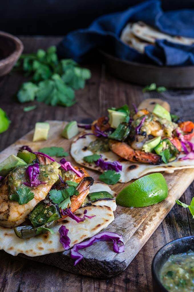 Grilled shrimp tacos with tomatillo salsa and homemade tortillas - bursting with flavor, juicy shrimp, grilled ppoblano peppers and tomatoes, topped with freshly made salsa verde, and served over soft homemade flour tortillas. | www.viktoriastable.com