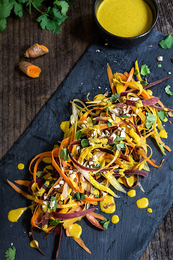 Carrot almond salad - ribbons of rainbow carrots, doused in creamy, turmeric coconut dressing, topped with toasted almonds and fresh cialntro - an explosion of exotic flavors that will surely tantalize your taste buds! | www.viktoriastable.com