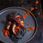 Grilled octopus over squid ink pasta and tomato garlic sauce | www.viktoriastable.com